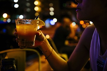 Woman’s hand holding a cocktail in a bar near Sea Spray Inn, Lauderdale-by-the-Sea